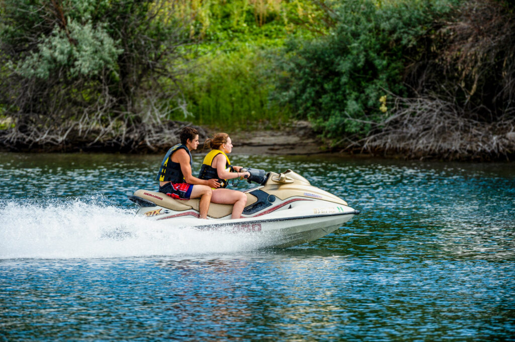 Young woman and young man jetskiing 