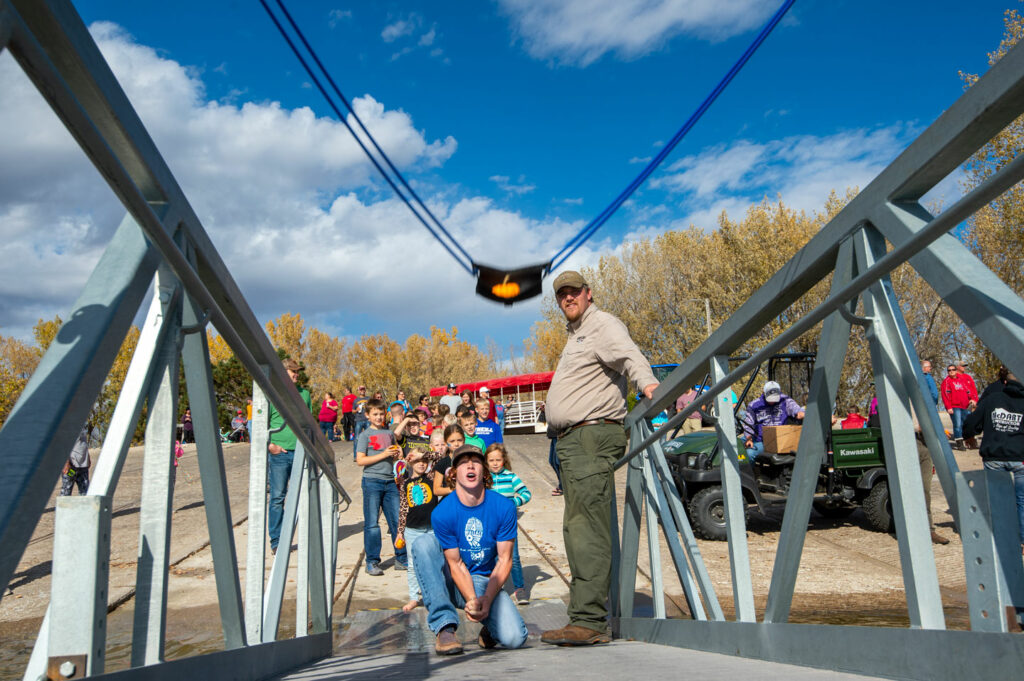 A teen launches a pumpkin from a slingshot