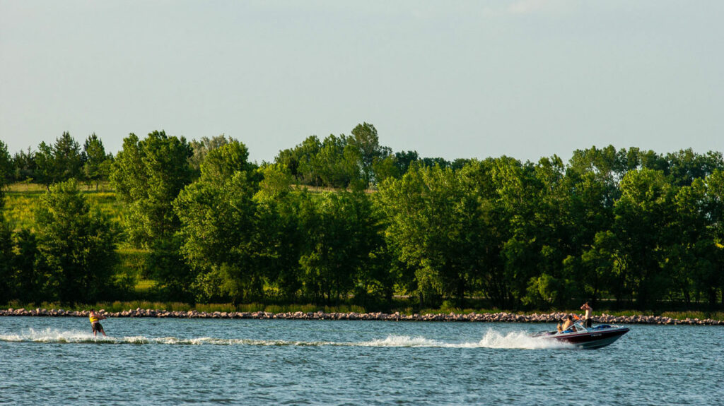 a motorboat pulls a waterskiier on the lake