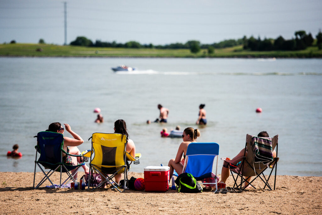 People relax on the swim beach in Area 1