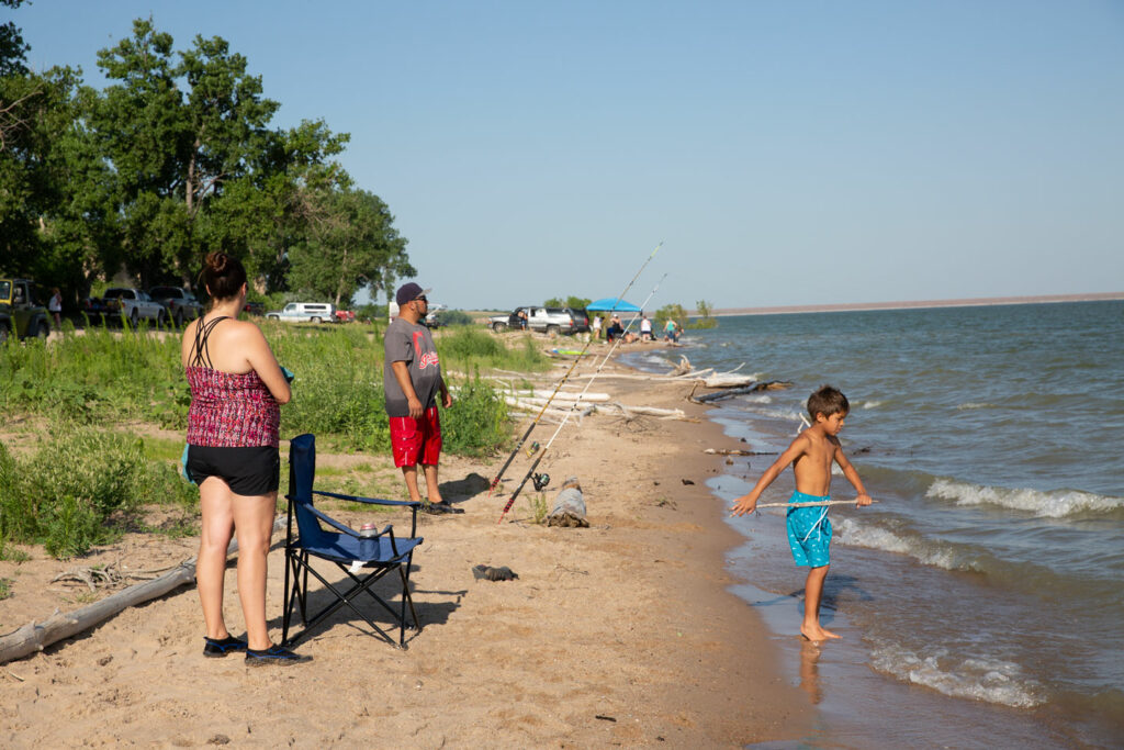 A family fishing on the beach.