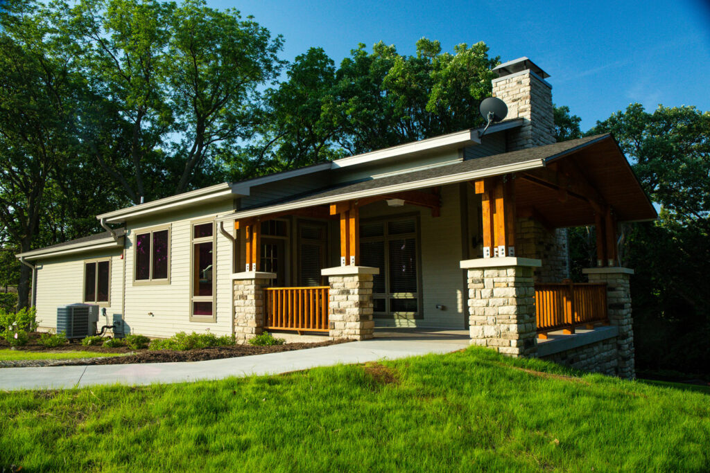 a modern cabin with wood and stone accents on a sunny day