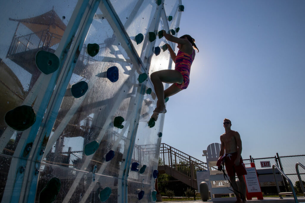 Pictured is the Ponca State Park Aquatic Center pool in Dixon County. Madeline Kurrus of Gretna is pictured climbing a wall over the pool. Kurrus, July 24, 2017. Copyright NEBRASKAland Magazine, Nebraska Game and Parks Commission.