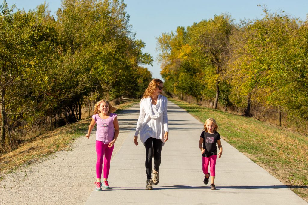 Two girls and a woman hike a trail