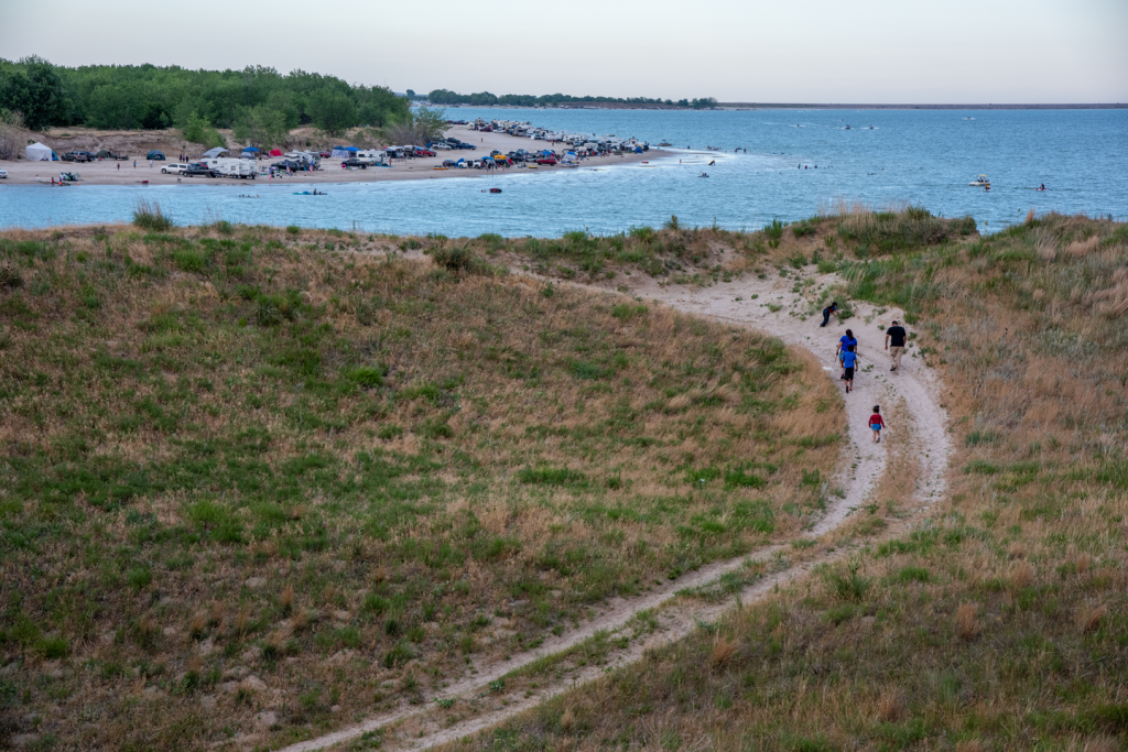 A family walks a trail road toward the lake