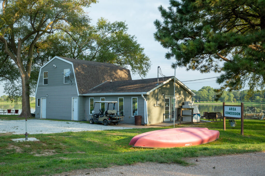 Sun gleams off of a tan concession building and a red kayak at Memphis State Recreation Area.