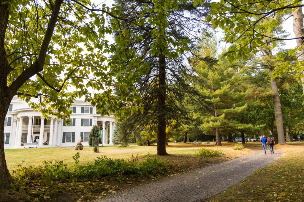 People walk down a tree-lined path at Arbor Lodge State Historical Park