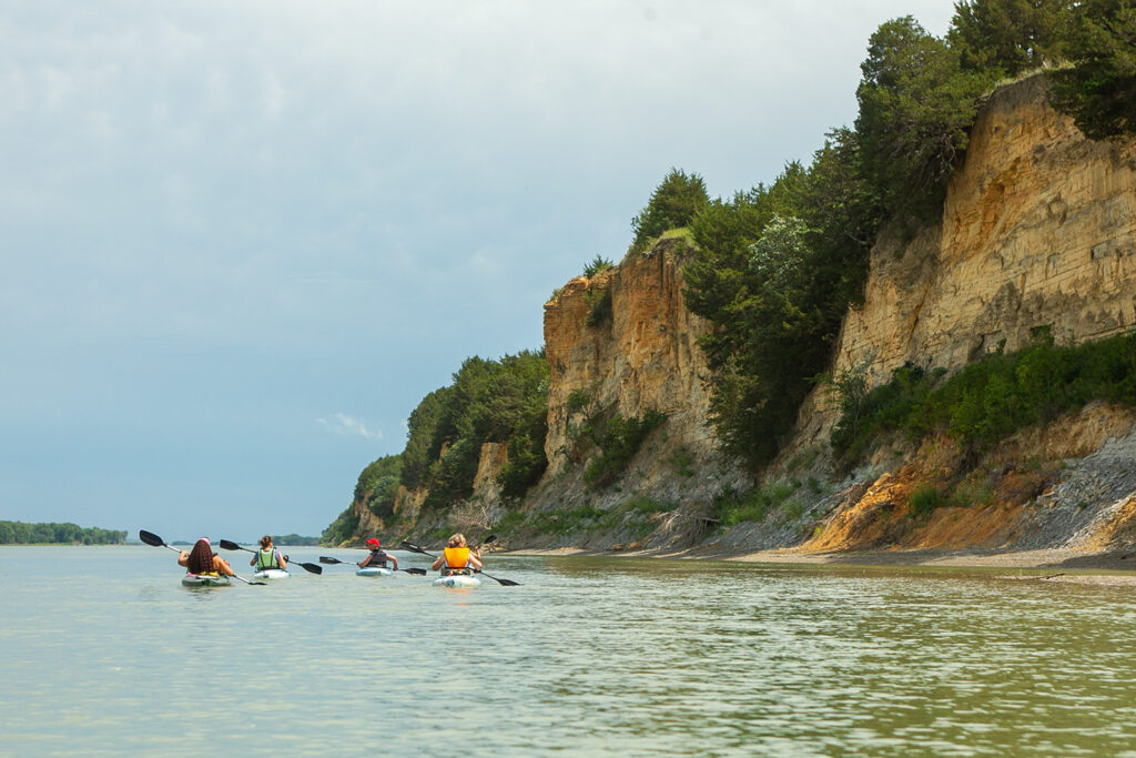 Women kayaking near cliffs at Lewis and Clark SRA in Nebraska