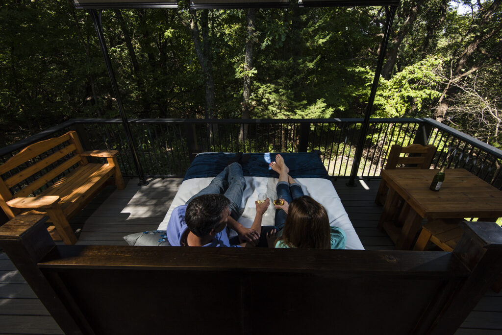 Melissa Panella and Joel Jorgensen of Lincoln sit on the deck of a new glamping cabin at Platte River State Park in Cass County. The cabins were built as part of the Venture Parks initiative. Fowler, September 27, 2018. Copyright NEBRASKAland Magazine, Nebraska Game and Parks Commission.