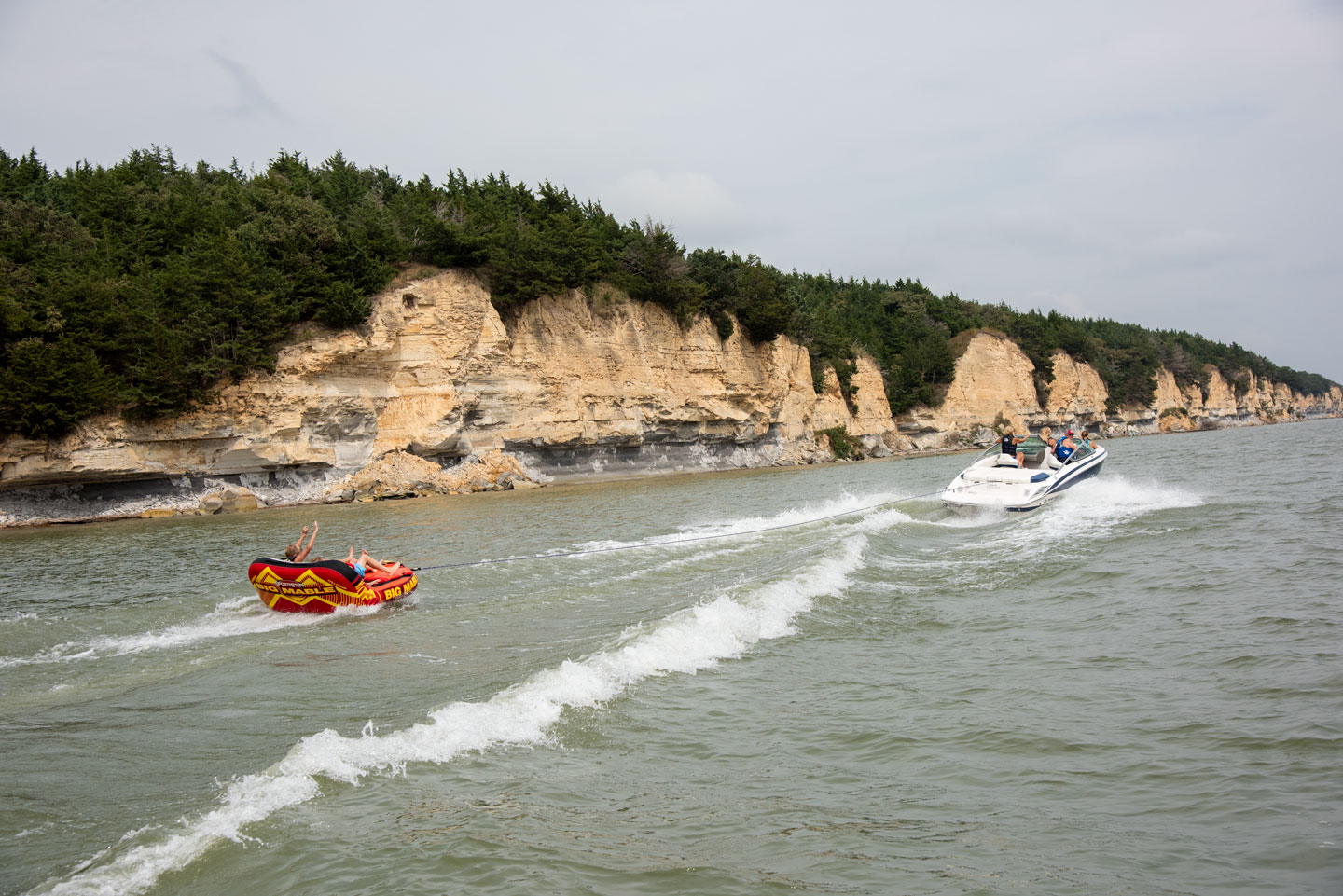 A speedboat pulls a ski tube across Lewis and Clark Lake SRA.