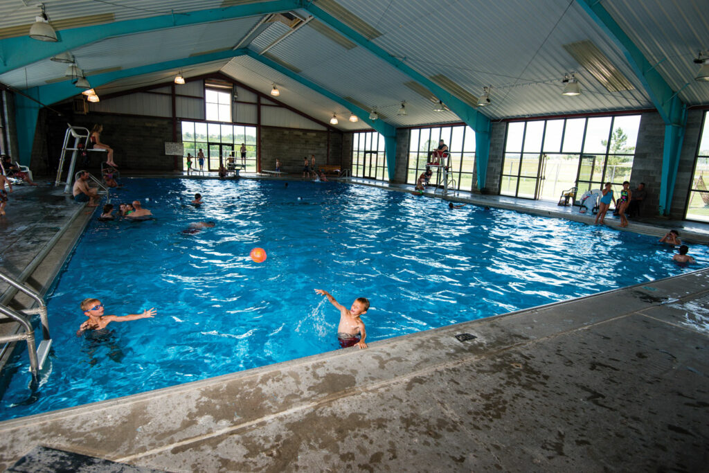 Boys play with a ball in an indoor pool