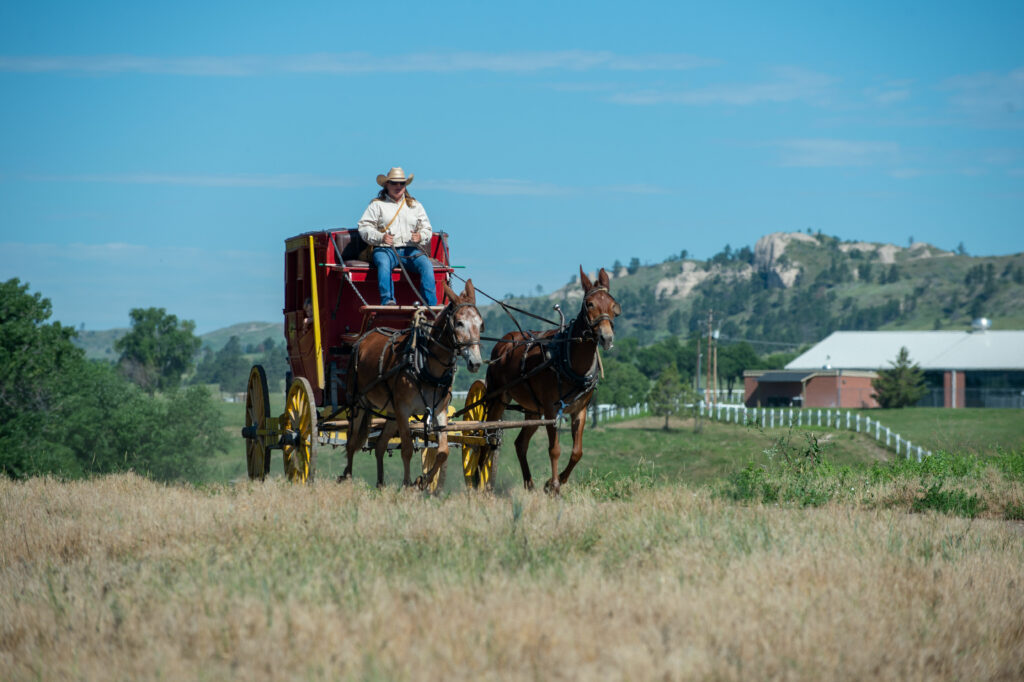 A replica vintage red stagecoach drives across Fort Robinson State Park grounds