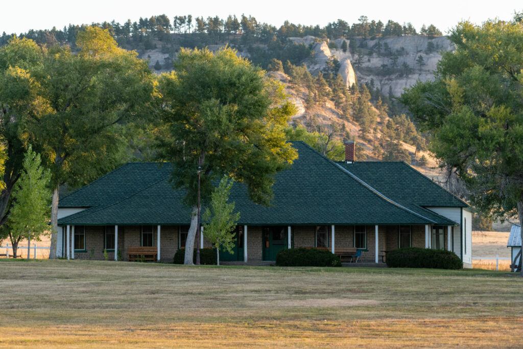 a lodge cabin sits in front of the buttes