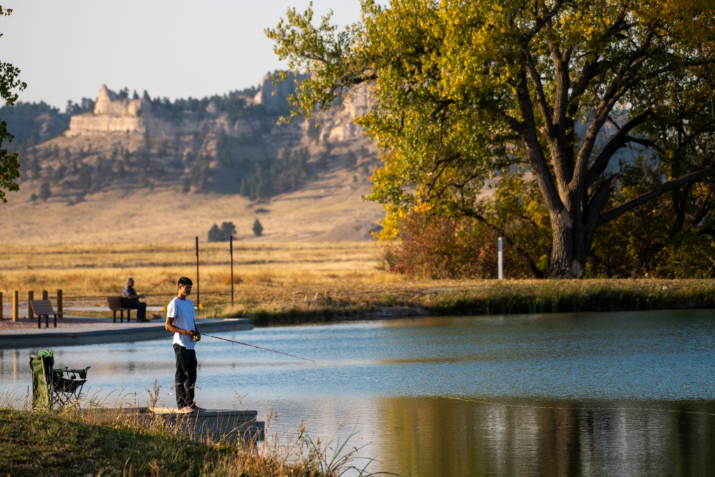 A young man fishes from a dock