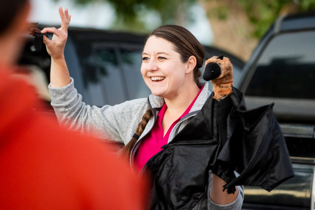 A woman holds up a bat puppet