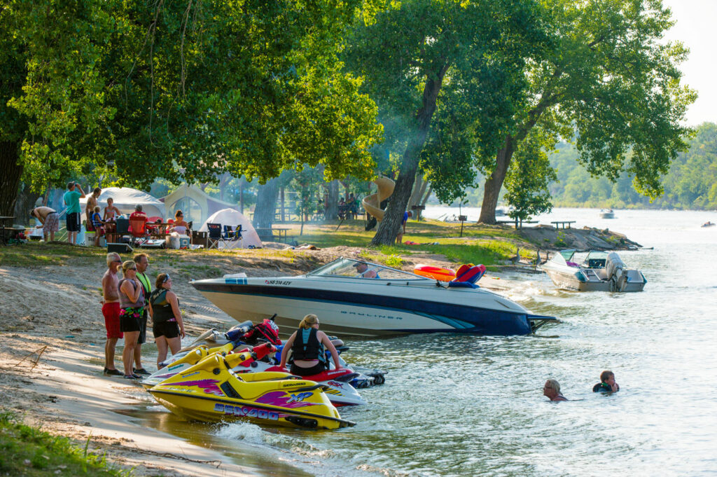 People relax and swim on the a beach on Victory Lake at Fremont Lakes SRA.