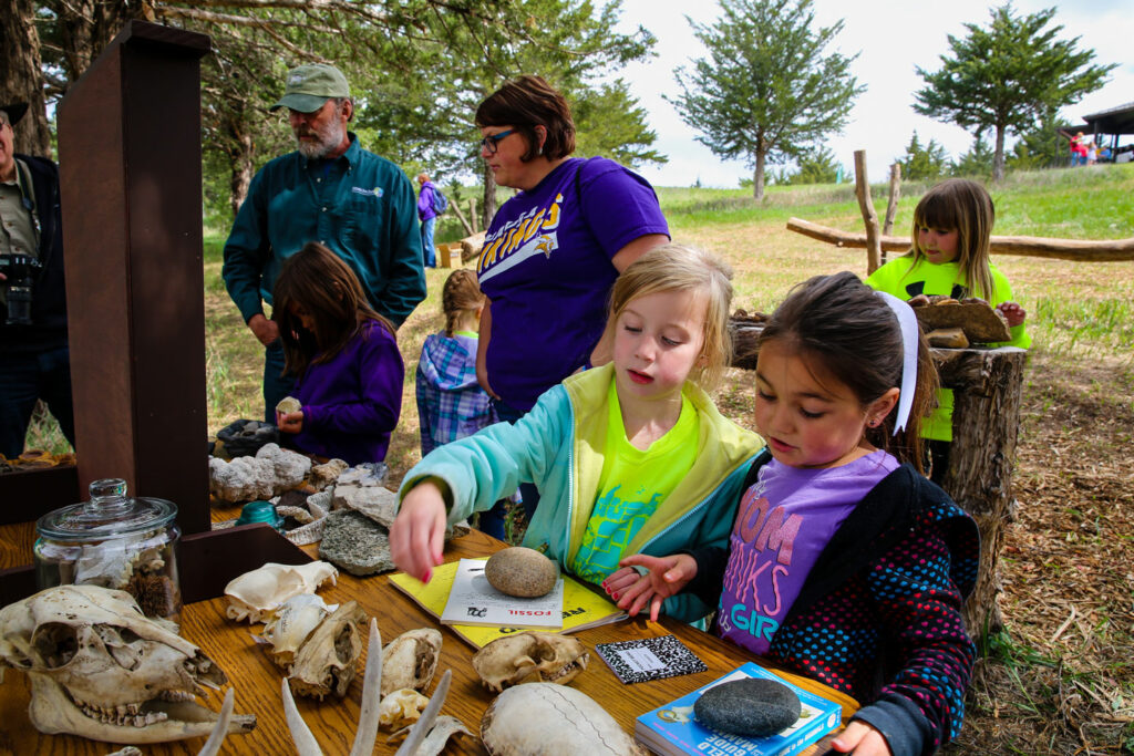 Children observe animal skulls at an outdoor education rendezvous at Niobrara State Park.