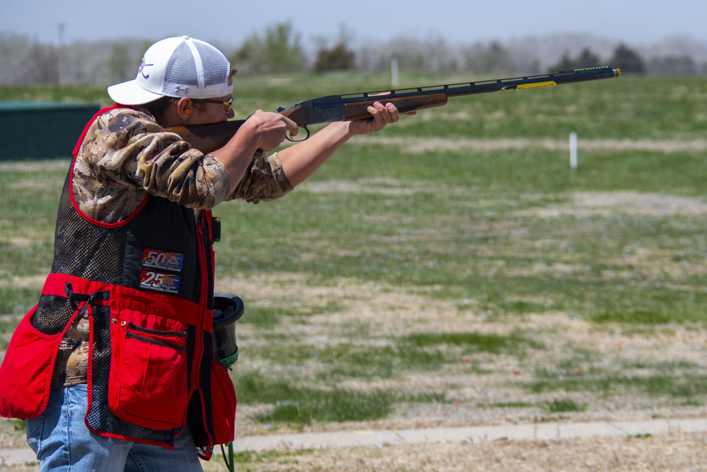 A teen boy shoots targets