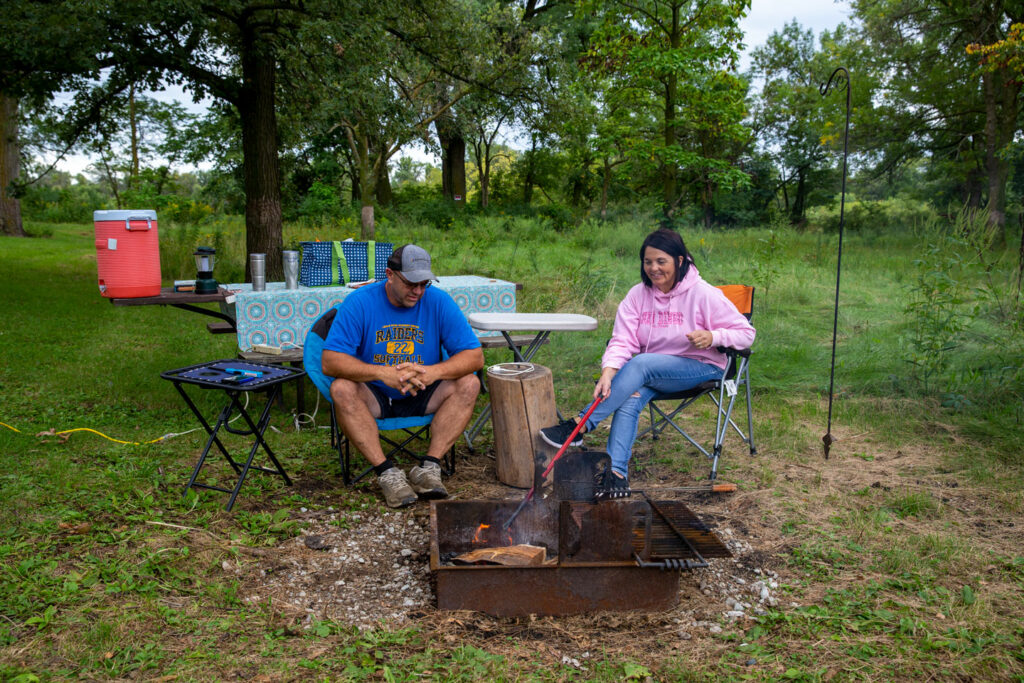 A husband and wife at a campfire