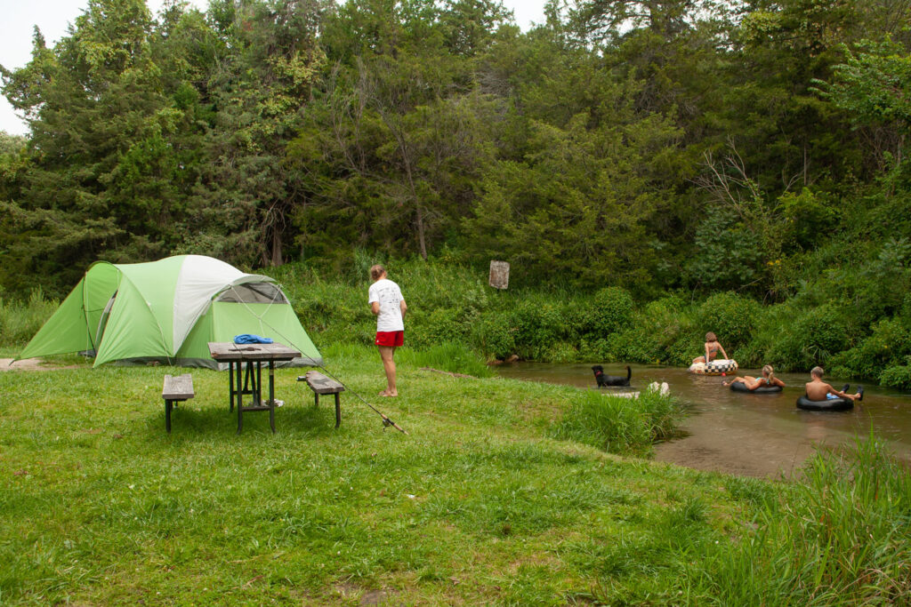 Tubers ride float down Long Pine Creek past a campground at Long Pine SRA.