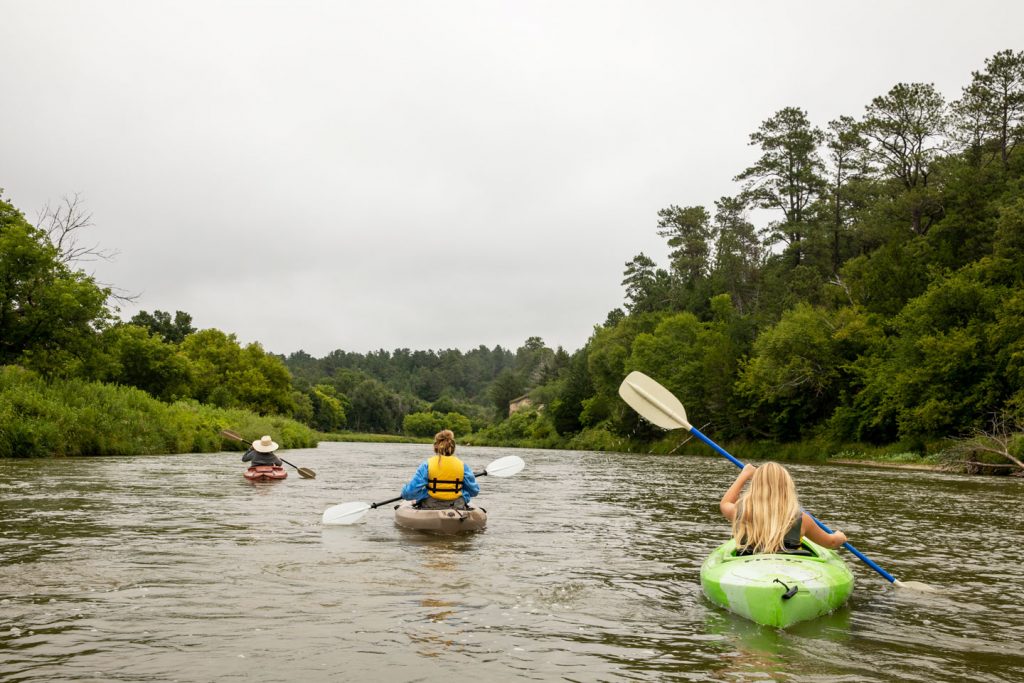 Three ladies kayaking on the scenic tree-lined Niobrara River 